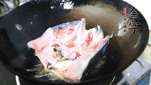 魚(yú)頭處理干凈后對(duì)半切開(kāi)，入加熱油的鍋中略煎。