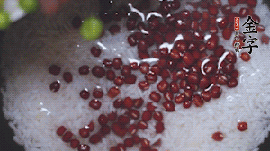 將炒好的食材和大米、紅豆一起放進(jìn)電飯鍋煮。