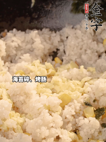 剩米飯下鍋炒散，依次下玉米粒、雞蛋、烤腸、海苔碎翻炒均勻。