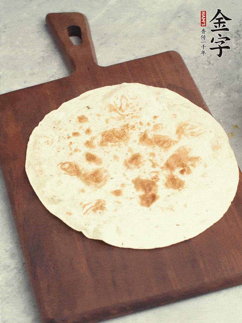 食材依次鋪在卷餅皮上，卷起來(lái)。