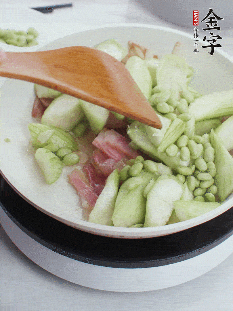 依次下絲瓜、青豆翻炒，炒至絲瓜打蔫縮小。