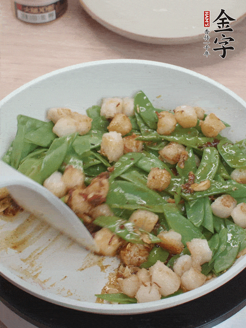 下甜豆莢、鮮貝輕輕翻炒均勻。