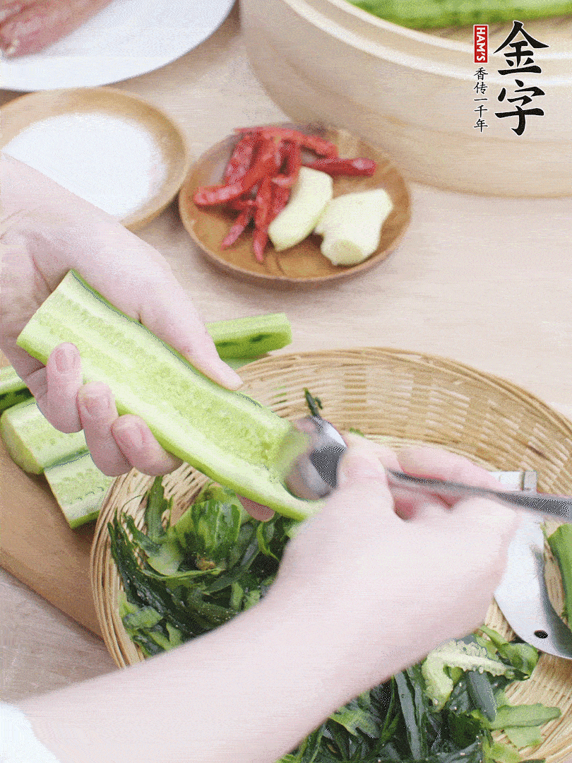 黃瓜削皮，對半切開，勺子挖去內(nèi)瓤，斜刀切片。青蒜斜刀切段。