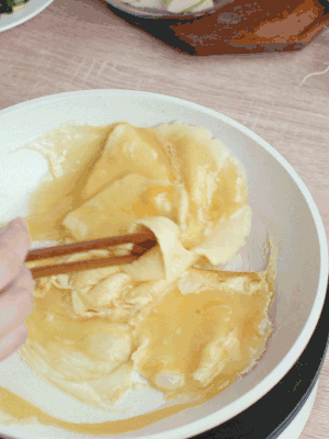 油6成熱時(shí)，下雞蛋液，邊緣凝固時(shí)翻拌成塊狀。