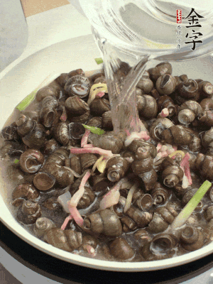 倒處理干凈的螺螄翻炒，加3勺料酒。加清水蓋過(guò)螺螄，中火蓋蓋煮5分鐘。