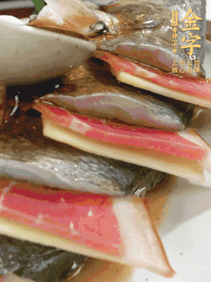 魚肚中塞蔥結、火腿片，魚身上碼放姜片、火腿片，倒入混合的料汁。