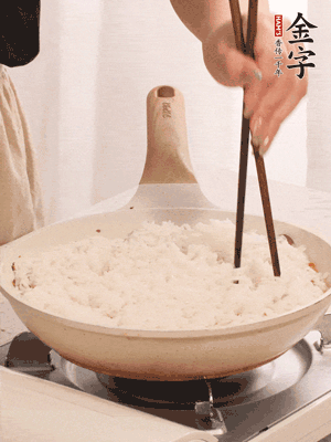 把瀝干水分的米飯均勻鋪在上面，筷子戳幾個洞，以便透氣，轉(zhuǎn)小火蓋上蓋子燜至水分收干，大概10分鐘。